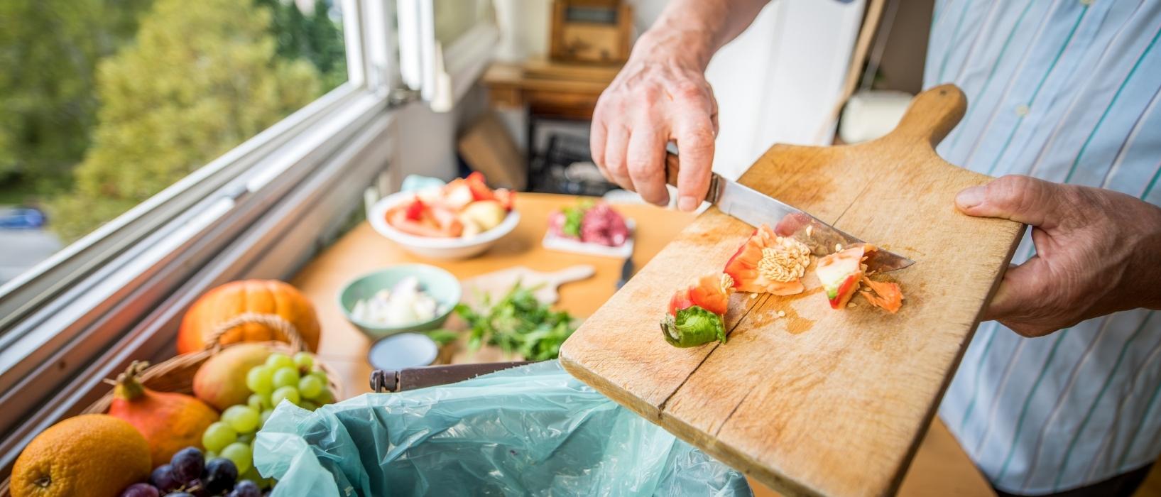 man throwing food waste away into compost bin