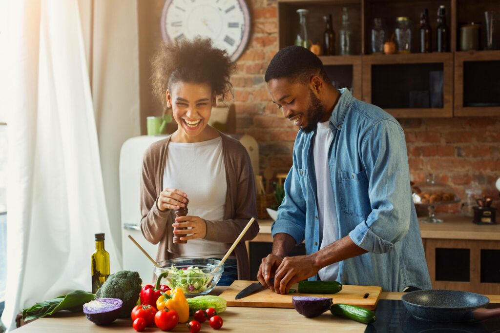 a couple chopping vegetables and cooking in their kitchen